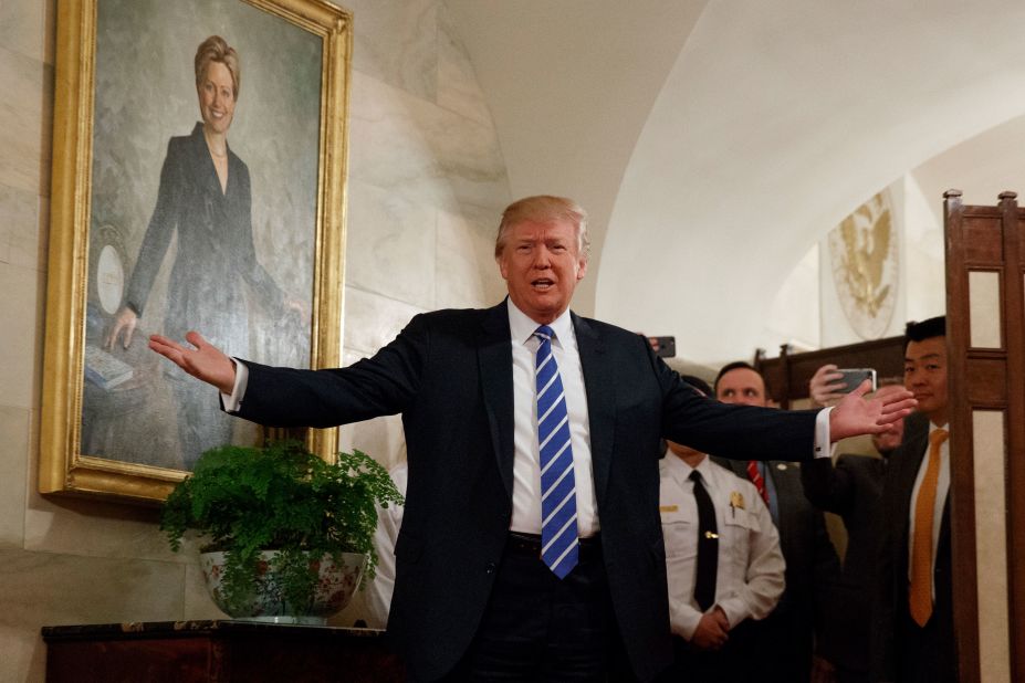 Trump, in front of a portrait of his 2016 opponent Hillary Clinton, <a href=
