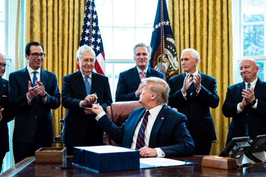 Trump hands a pen to Senate Majority Leader Mitch McConnell during a bill-signing ceremony for the Coronavirus Aid, Relief and Economic Security Act in March 2020.