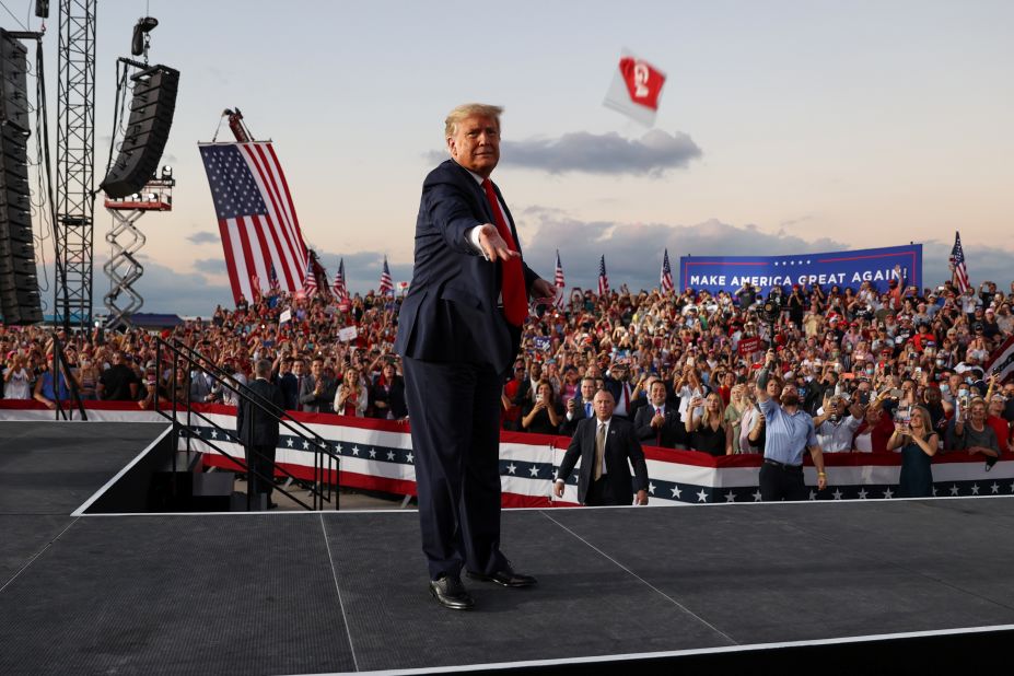 Trump tosses face masks to the crowd as he takes the stage for a campaign rally in Sanford, Florida, on October 12, 2020.